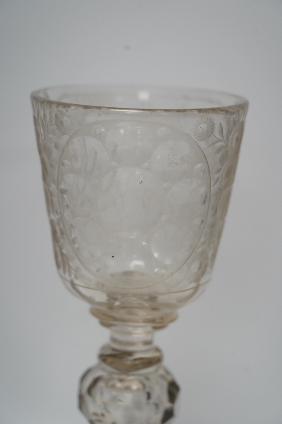 A Victorian engraved tall stemmed wine glass with white metal mounted foot rim, 22cm high. Condition - fair to good